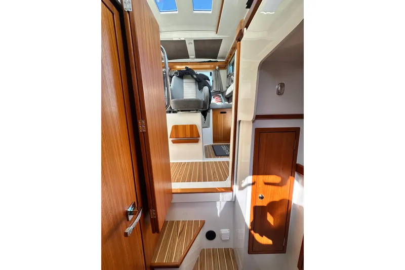 Slide: The Image of Interior of 2018 Sargo 25 boat, featuring wooden finishes and seating area. - 23