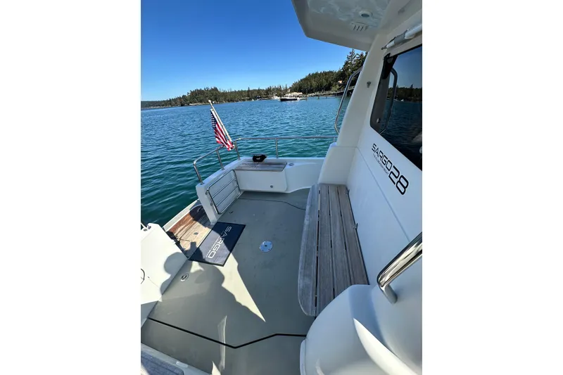 Slide: The Image of 2018 Sargo 25 boat deck with American flag, docked on serene blue water. - 7