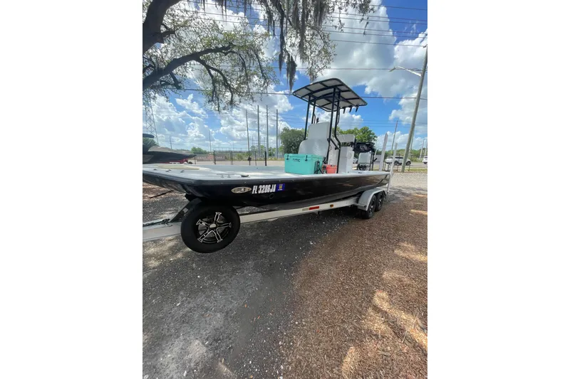 The Image of 1993 Hurricane FunDeck 196 FF boat on trailer under a tree, sunny day. - 1