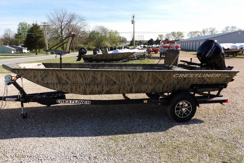 Slide: The Image of 2026 Crestliner 1860 Retriever Deluxe boat on trailer, camo design, parked outdoors. - 13