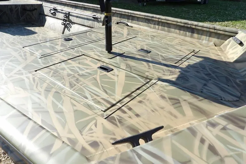 Slide: The Image of 2026 Crestliner 1860 Retriever Deluxe boat with camouflage pattern and storage compartments. - 16