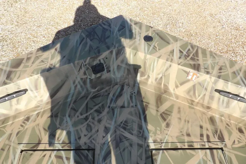 Slide: The Image of 2026 Crestliner 1860 Retriever Deluxe boat with camouflage pattern and shadow. - 18