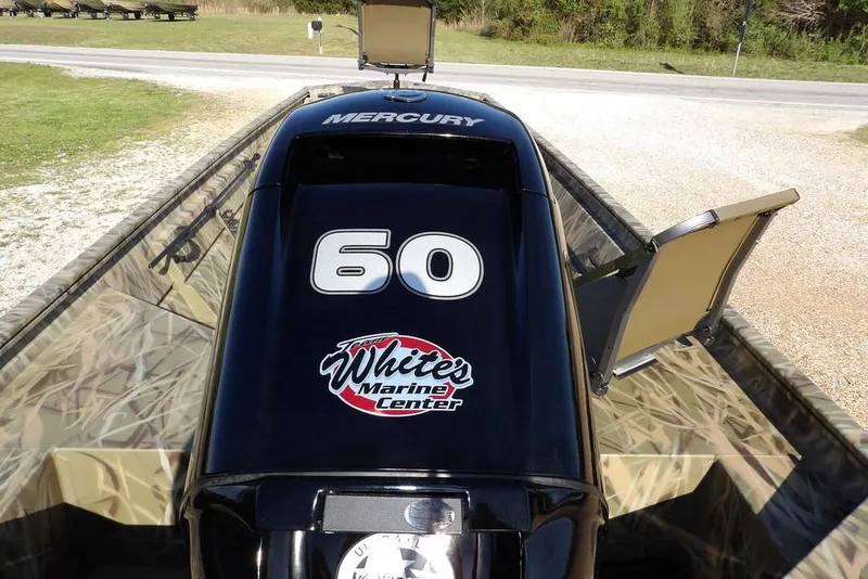 Slide: The Image of 2026 Crestliner 1860 Retriever Deluxe boat with Mercury engine, featuring camo design and open storage. - 20