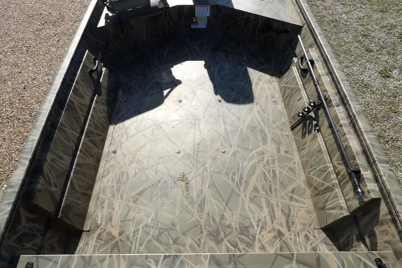 Slide: The Image of 2026 Crestliner 1860 Retriever Deluxe boat interior with camouflage design and fishing rod holders. - 23