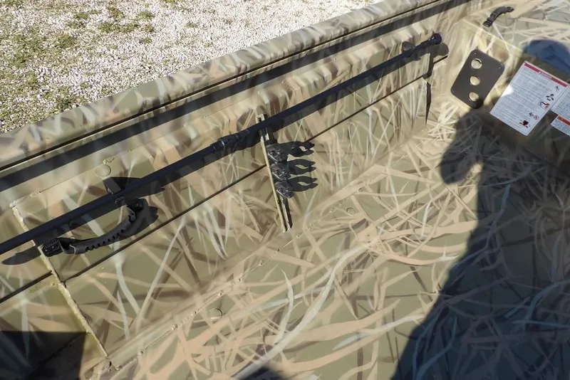 Slide: The Image of 2026 Crestliner 1860 Retriever Deluxe interior with camouflage design and rod holder. - 24