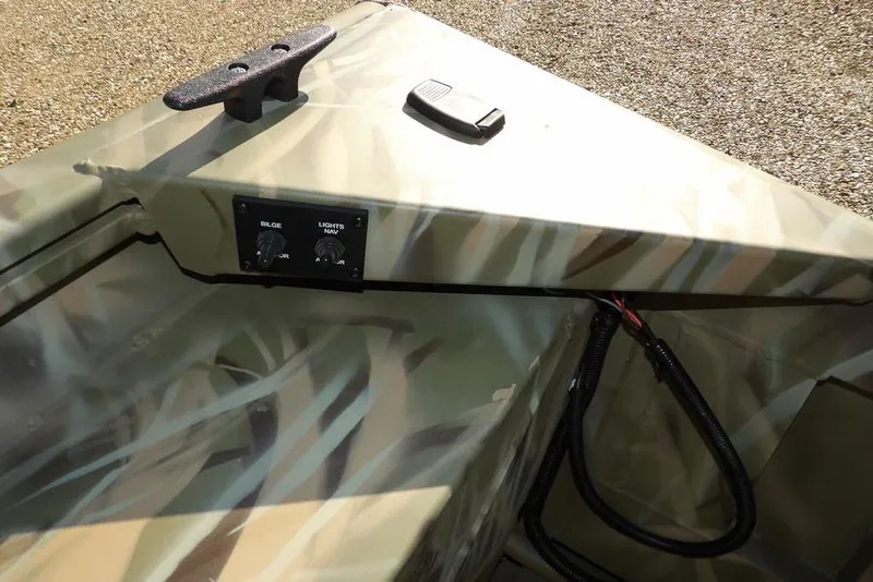 Slide: The Image of 2026 Crestliner 1860 Retriever Deluxe boat interior with camouflage design and control panel. - 26