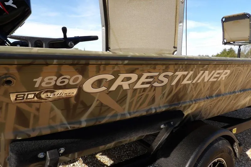 Slide: The Image of 2026 Crestliner 1860 Retriever Deluxe boat with camouflage design on trailer. - 34