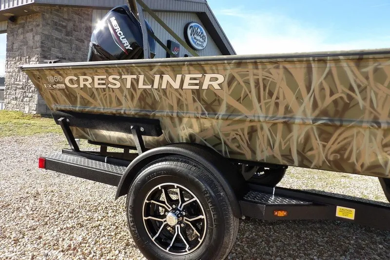 Slide: The Image of 2026 Crestliner 1860 Retriever Deluxe boat with camouflage design on a trailer. - 36