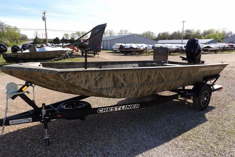 Slide: The Image of 2026 Crestliner 1860 Retriever Deluxe boat on trailer, camo design, parked outdoors. - 5