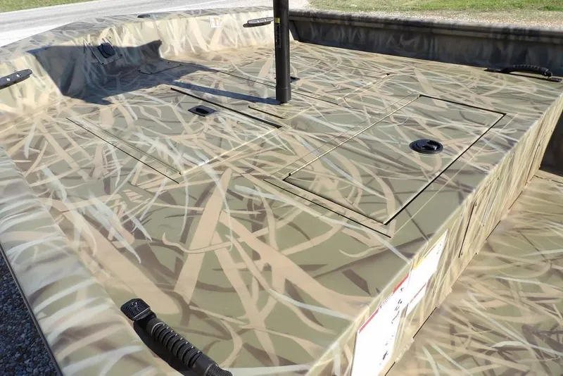 Slide: The Image of 2026 Crestliner 1860 Retriever Deluxe boat with camouflage design, featuring storage compartments. - 8