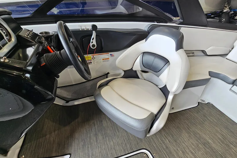 Slide: The Image of Interior of a 2021 Scarab 195 ID boat featuring a sleek steering wheel and comfortable seating. - 11