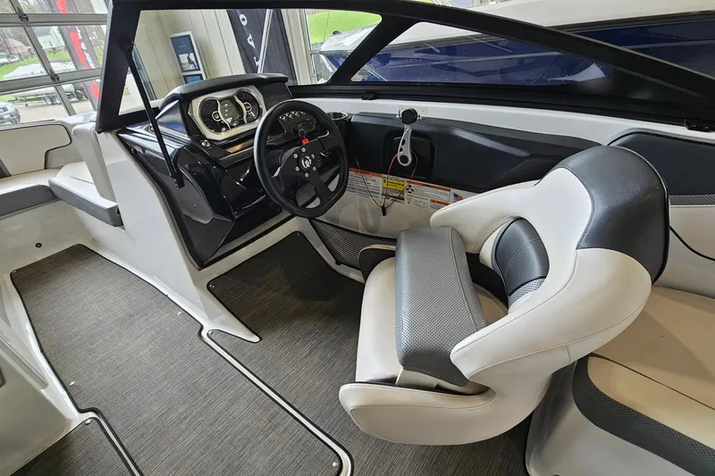 Slide: The Image of Interior of a 2021 Scarab 195 ID boat, featuring modern steering and seating. - 12