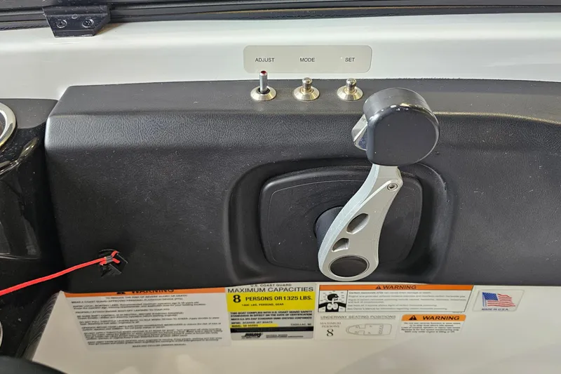 Slide: The Image of Control panel of a 2021 Scarab 195 ID boat with throttle lever and capacity warnings. - 25