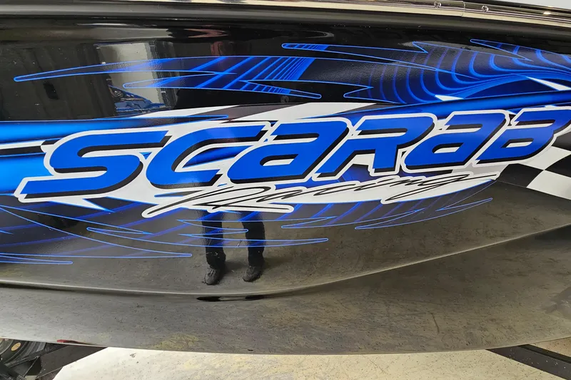 Slide: The Image of 2021 Scarab 195 ID boat with bold blue racing graphics. - 27