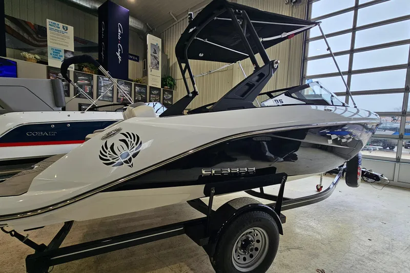 Slide: The Image of 2021 Scarab 195 ID boat on trailer in showroom, featuring sleek design and modern graphics. - 3