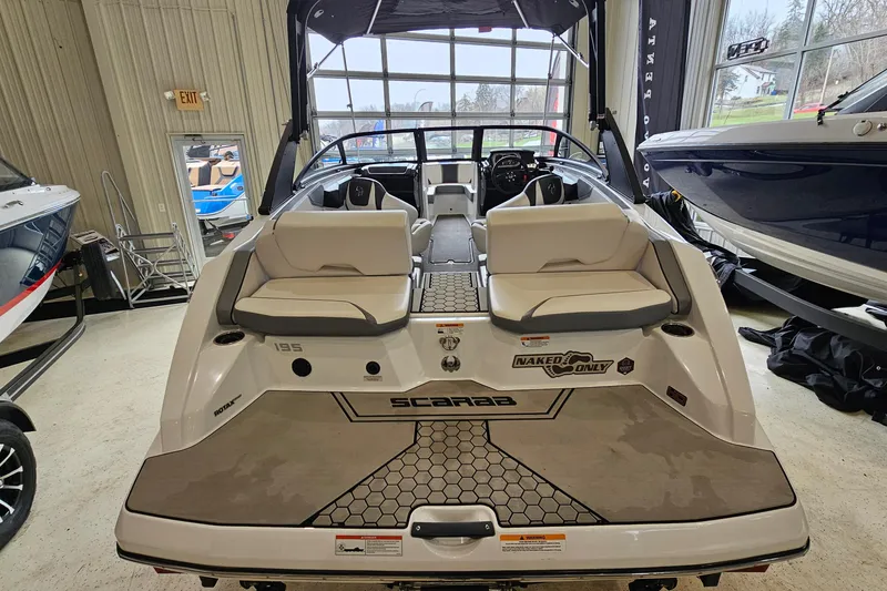 Slide: The Image of 2021 Scarab 195 ID boat in showroom, rear view with seating and branding. - 4