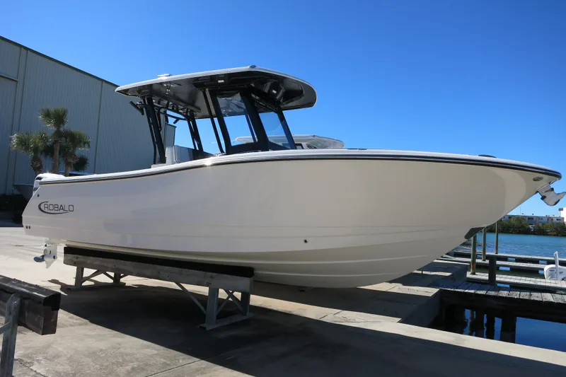 The Image of 2026 Robalo R270 Center Console boat on display at a marina dock. - 1