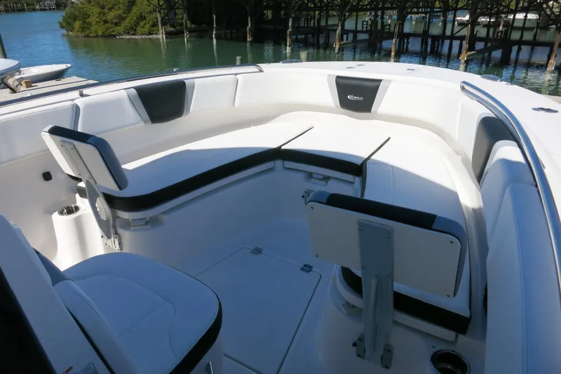 Slide: The Image of 2026 Robalo R270 Center Console boat interior with white seating and waterfront view. - 17