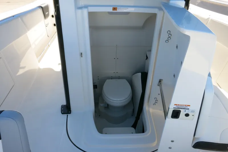 Slide: The Image of 2026 Robalo R270 Center Console boat interior with compact marine toilet. - 25