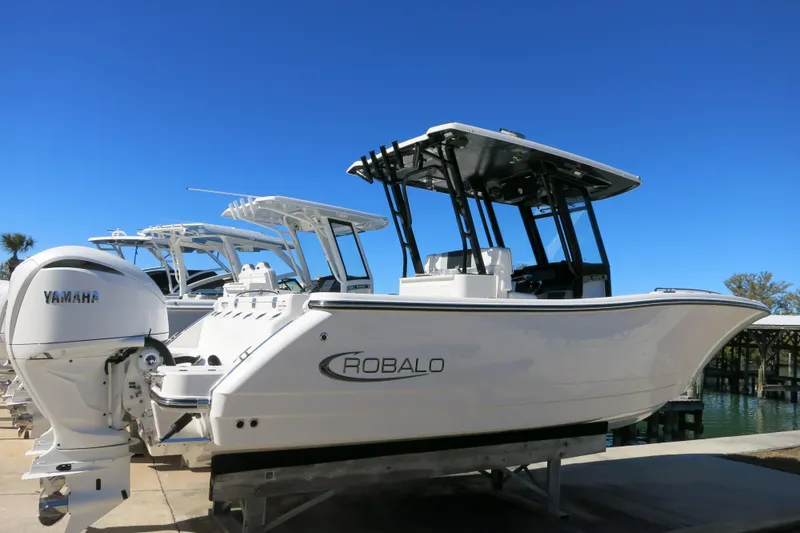 Slide: The Image of 2026 Robalo R270 Center Console boat with Yamaha engine, docked under clear blue sky. - 3