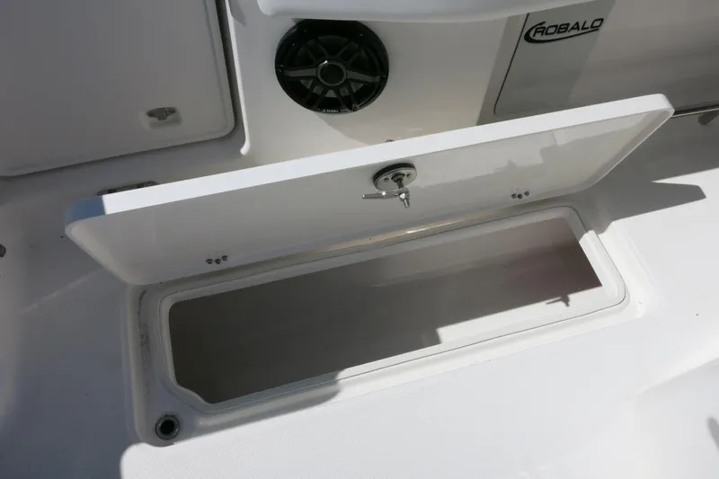 Slide: The Image of 2026 Robalo R270 Center Console storage compartment with open lid and speaker. - 30