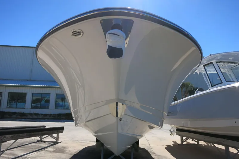 Slide: The Image of 2026 Robalo R270 Center Console boat, front view, displayed outdoors under clear blue sky. - 5