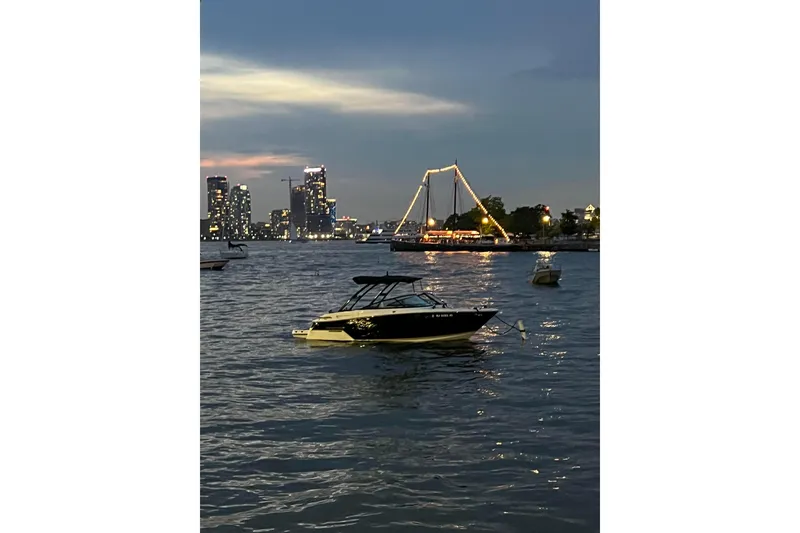 Slide: The Image of 2018 Monterey 258 Super Sport boat on water at dusk with city skyline. - 13