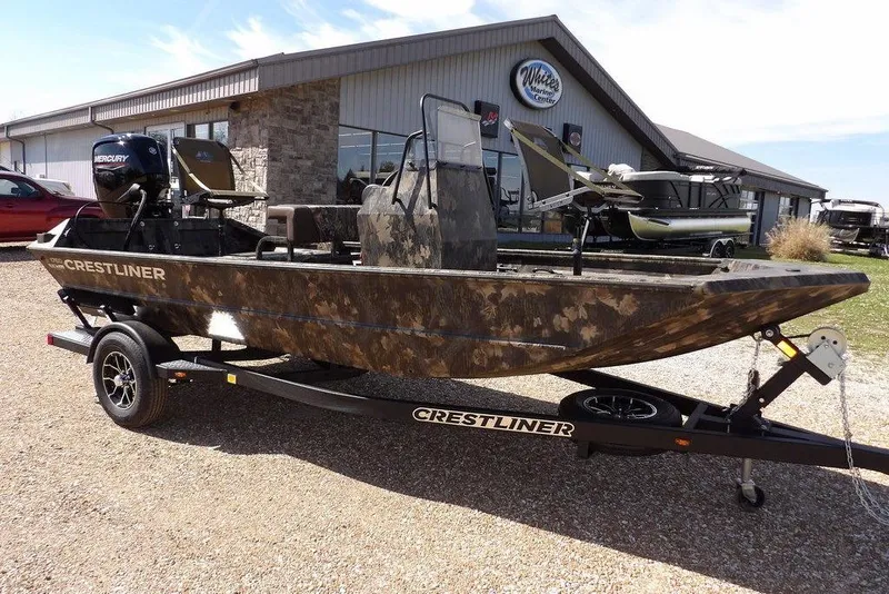 The Image of 2026 Crestliner 1760 Retriever FCC boat on trailer, parked outside a marine dealership. - 1