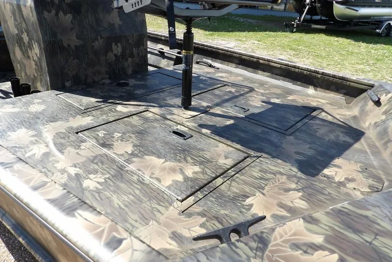 Slide: The Image of 2026 Crestliner 1760 Retriever FCC boat with camouflage design and storage compartments. - 12