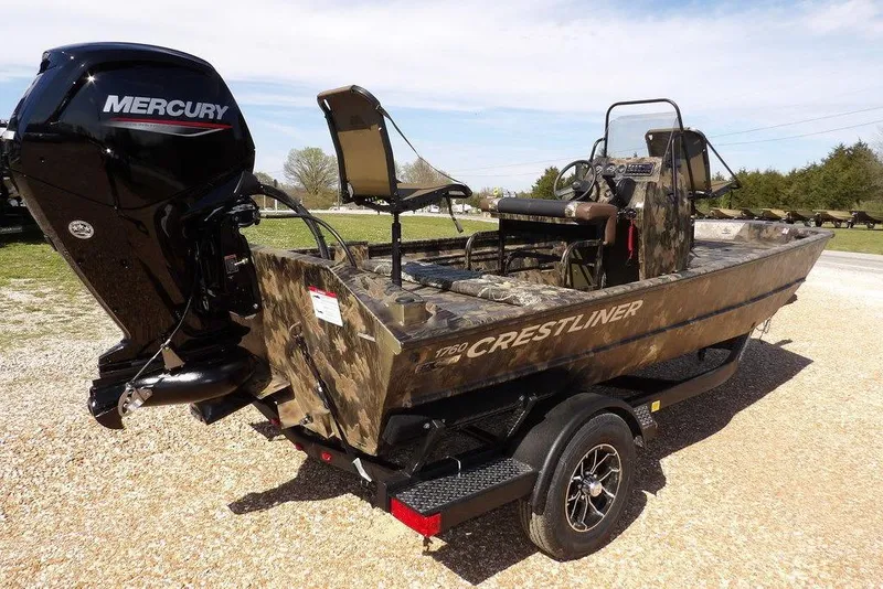 Slide: The Image of 2026 Crestliner 1760 Retriever FCC boat with Mercury engine, camo design, on trailer. - 13