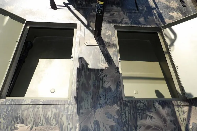 Slide: The Image of 2026 Crestliner 1760 Retriever FCC boat with open storage compartments and camouflage design. - 27