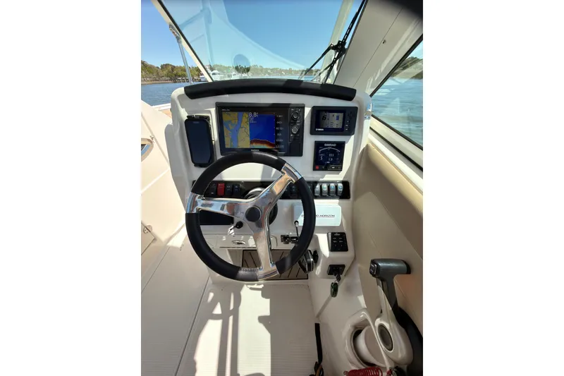 Slide: The Image of 2018 Sailfish 245 DC boat cockpit with steering wheel and navigation displays. - 10
