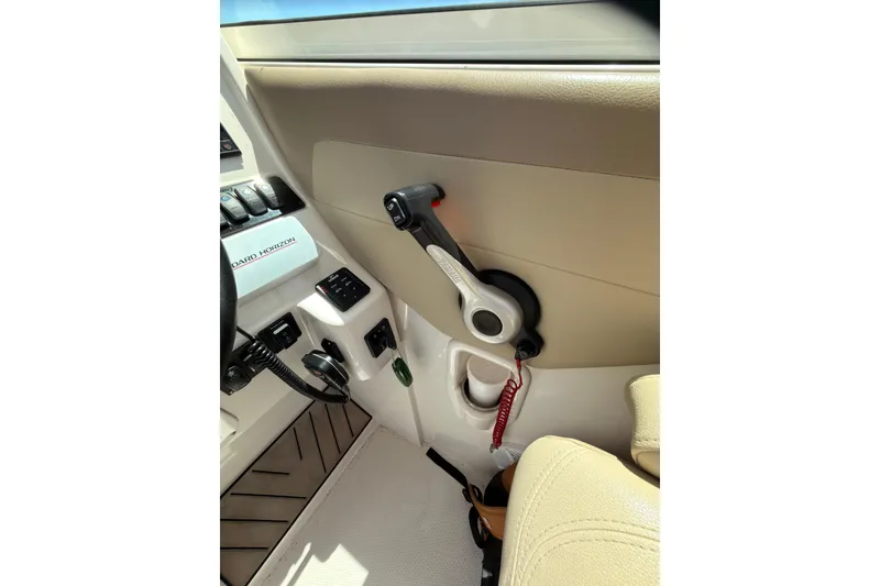 Slide: The Image of Interior view of a 2018 Sailfish 245 DC boat cockpit with control panel and throttle lever. - 15