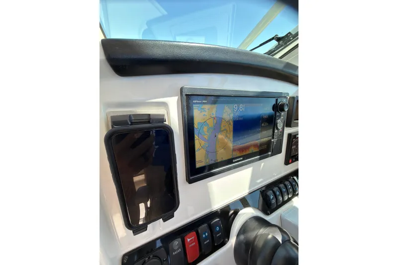 Slide: The Image of Interior of 2018 Sailfish 245 DC boat with beige captain's chair and steering wheel. - 16