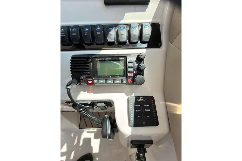 Slide: The Image of 2018 Sailfish 245 DC boat interior with beige seating on a calm river. - 19