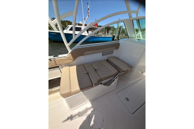 Slide: The Image of 2018 Sailfish 245 DC boat interior with beige seating and white framework. - 25