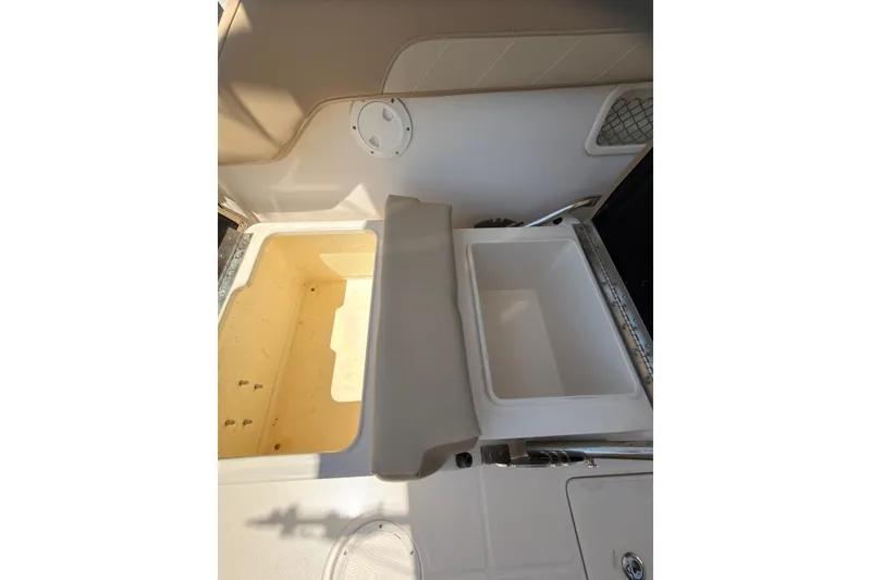 Slide: The Image of 2018 Sailfish 245 DC boat interior with storage compartments and seating. - 26