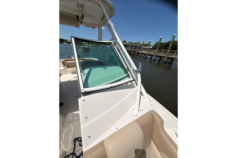 Slide: The Image of 2018 Sailfish 245 DC boat docked by a pier on a sunny day. - 28