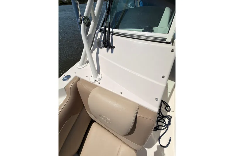 Slide: The Image of 2018 Sailfish 245 DC boat interior with beige seating and white console. - 29