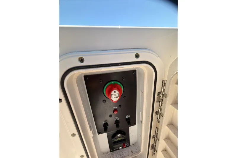 Slide: The Image of Control panel on a 2018 Sailfish 245 DC boat, featuring switches and a red button. - 32