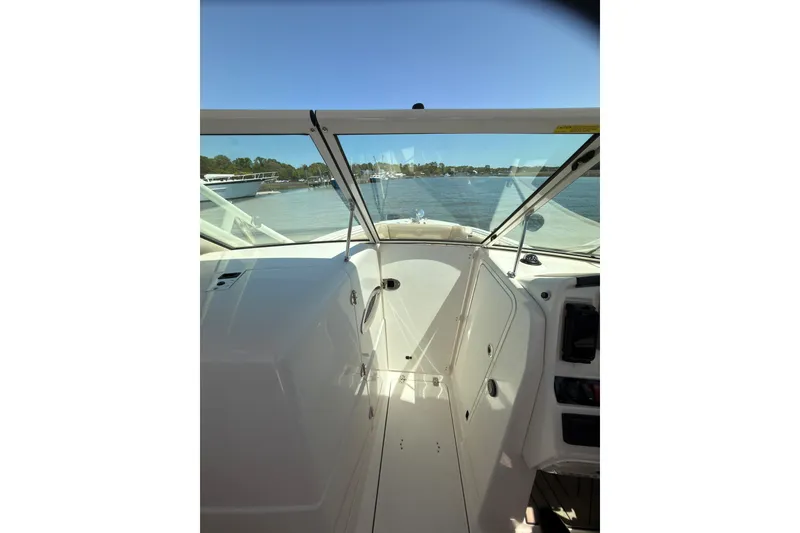 Slide: The Image of 2018 Sailfish 245 DC boat with beige seating, cruising on a calm lake. - 9