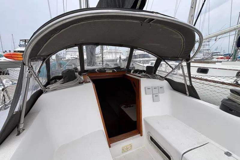 Slide: The Image of Cockpit of 1979 Islander Peterson 40 sailboat, featuring covered seating and marina view. - 19