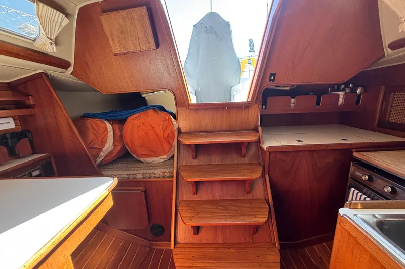Slide: The Image of Interior of 1979 Islander Peterson 40 sailboat with wooden cabinetry and compact kitchen area. - 39