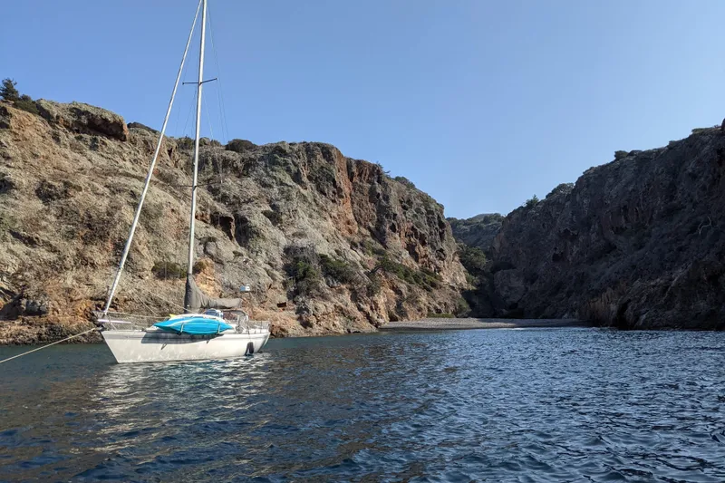 Slide: The Image of Sailboat Islander Peterson 40 (1979) anchored in a scenic rocky cove. - 4