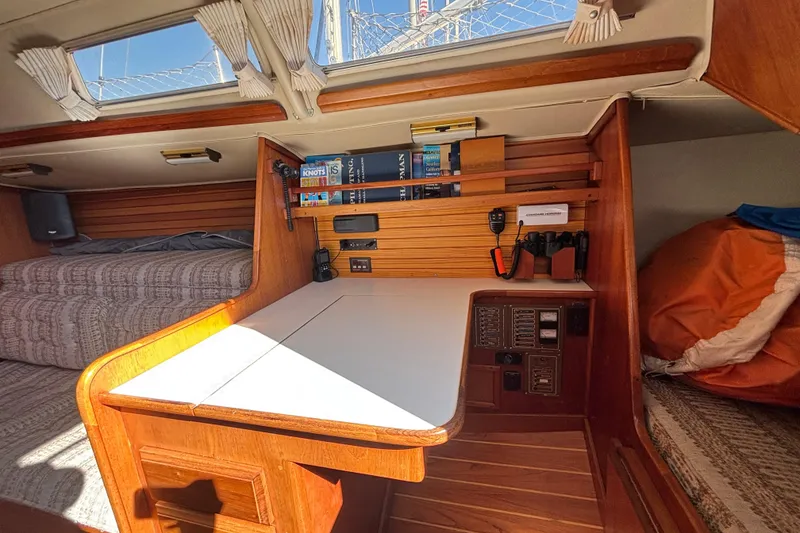 Slide: The Image of Interior of 1979 Islander Peterson 40 sailboat with navigation station and cozy sleeping area. - 43