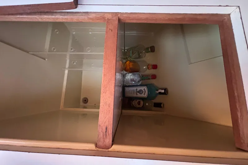 Slide: The Image of Storage compartment with assorted liquor bottles on a 1979 Islander Peterson 40 yacht. - 48