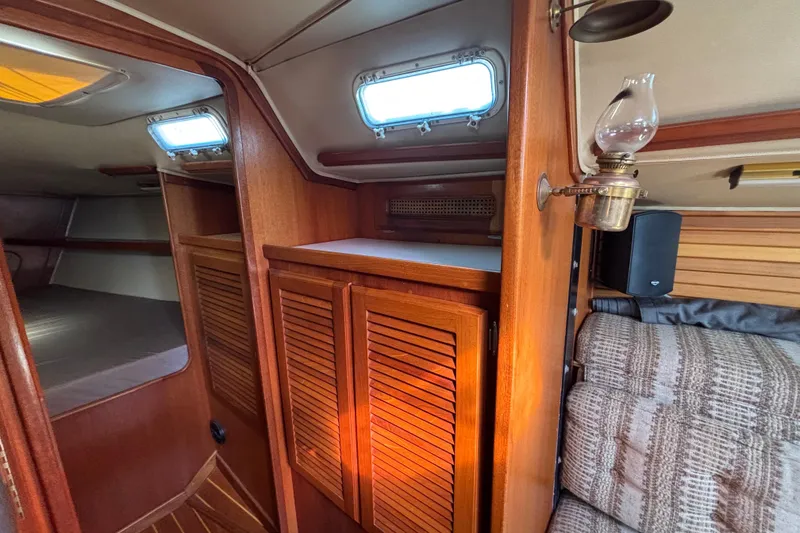 Slide: The Image of Interior of 1979 Islander Peterson 40 sailboat with wooden cabinets and vintage lamp. - 49
