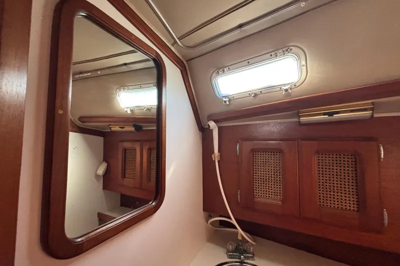 Slide: The Image of 1979 Islander Peterson 40 yacht interior with wooden cabinets and mirror. - 52
