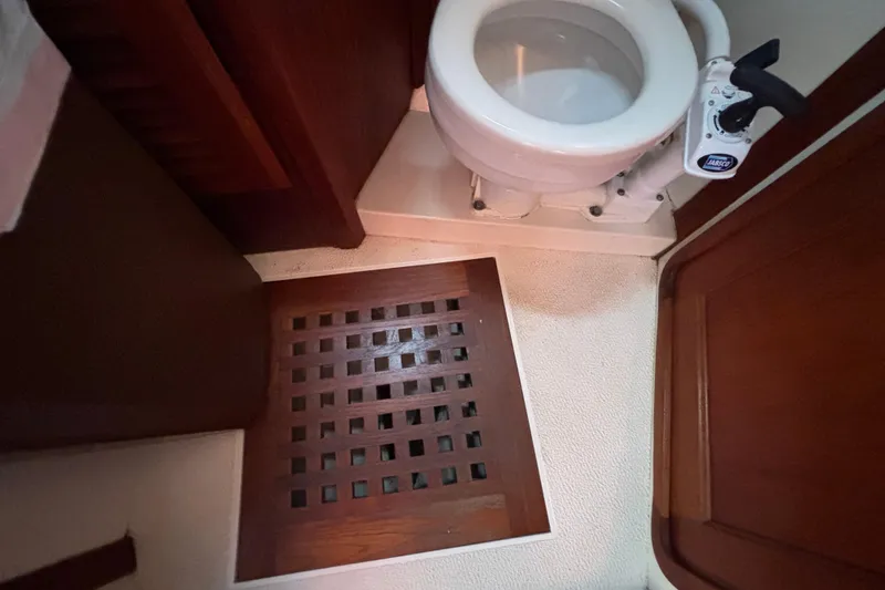Slide: The Image of 1979 Islander Peterson 40 yacht bathroom with wooden floor grate and marine toilet. - 53