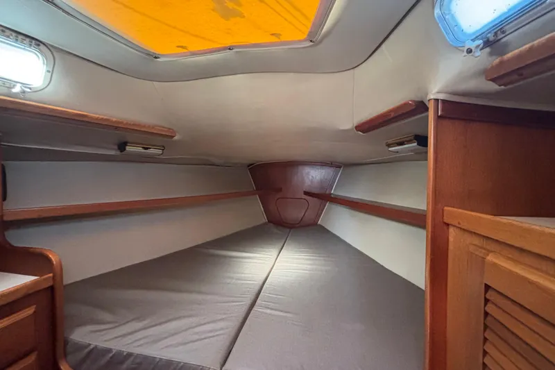 Slide: The Image of Interior cabin of 1979 Islander Peterson 40 sailboat, featuring wooden accents and cozy sleeping area. - 54